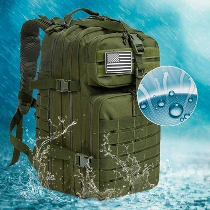 Mochila táctica impermeable en color verde militar con parche de la bandera estadounidense, ideal para expediciones de airsoft y misiones de campo.